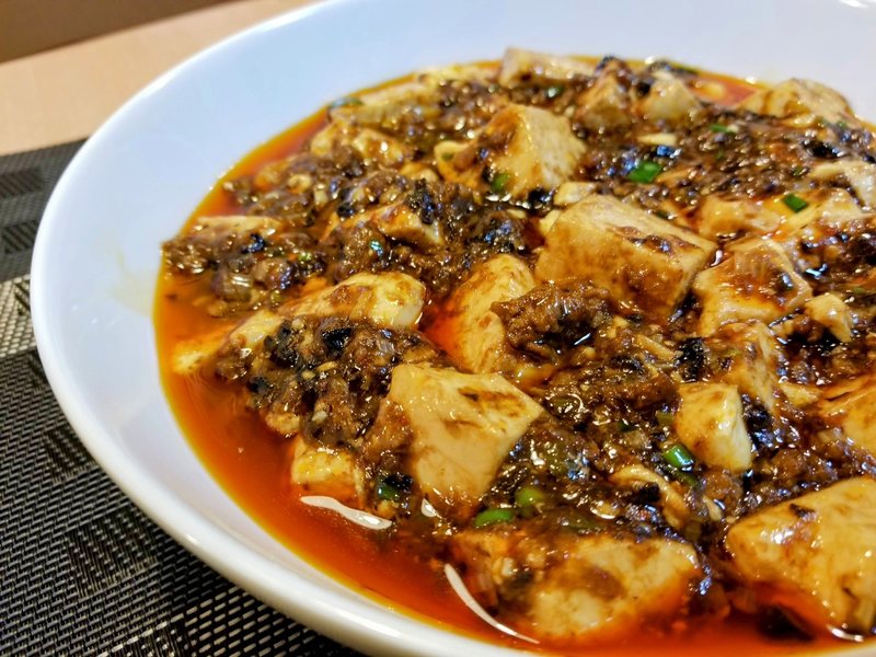 ゴリゴリの麻婆豆腐。豆腐と挽き肉に赤い辣油がまわった一皿