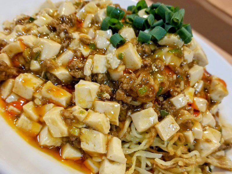 なおきゅう焼きそば。揚げた麺に豆腐と挽き肉のあんをかけた一皿